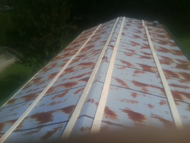 Rusted metal roof panels with new wood purlins before replacement — Storm Damage Roof Repair in Francis Creek by Roofing Brothers