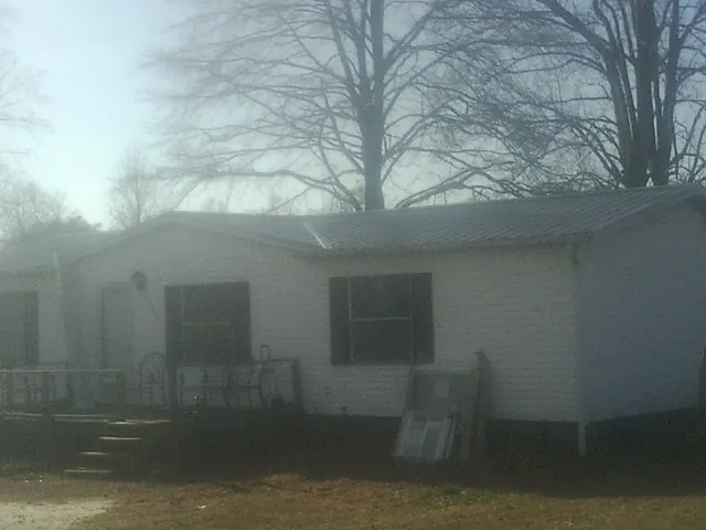 New metal roof on a white painted brick home on a foggy morning in Francis Creek