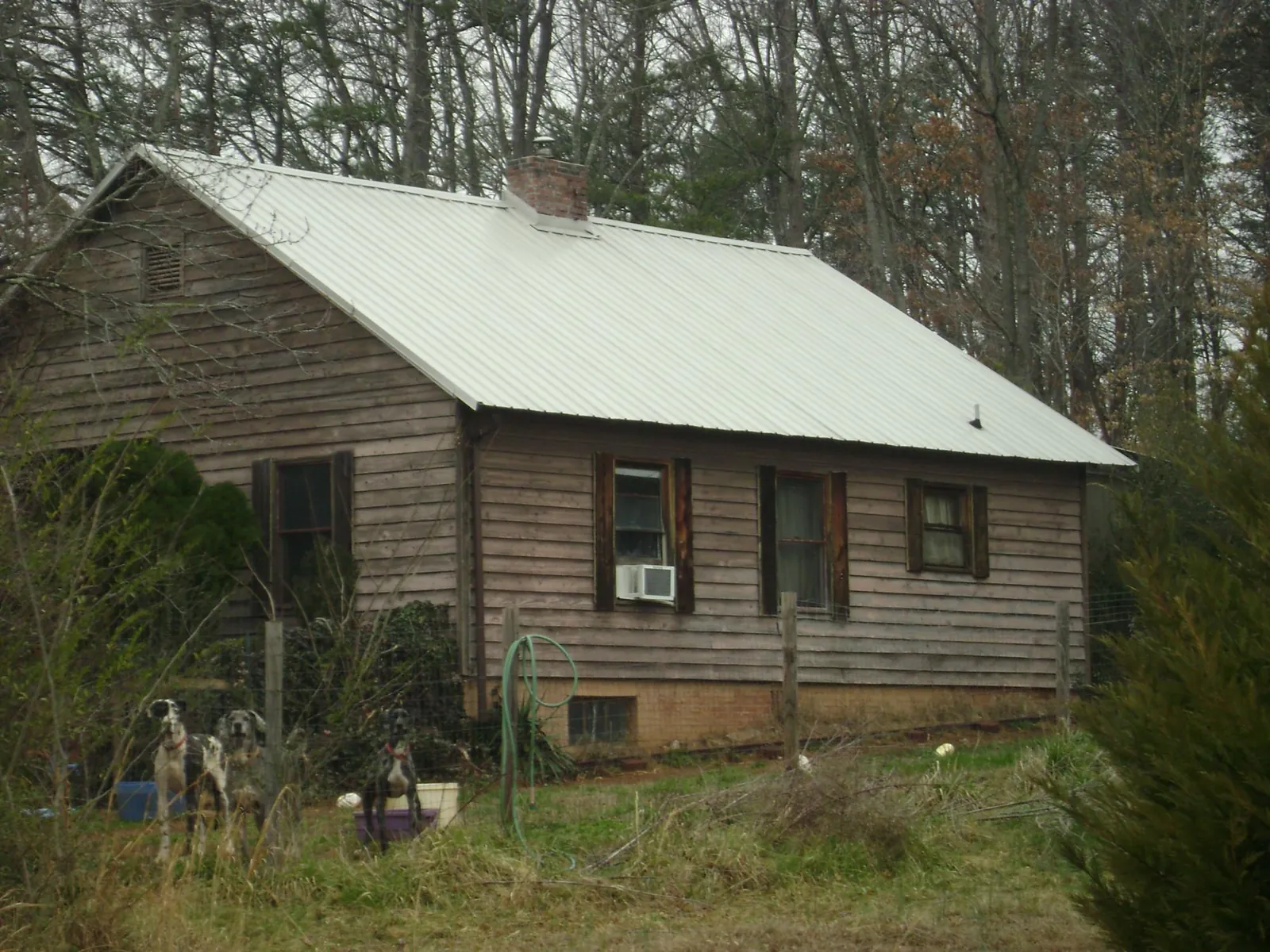 White metal roof on an old wood sided farmhouse, from a Metal Roof Installation job in Francis Creek